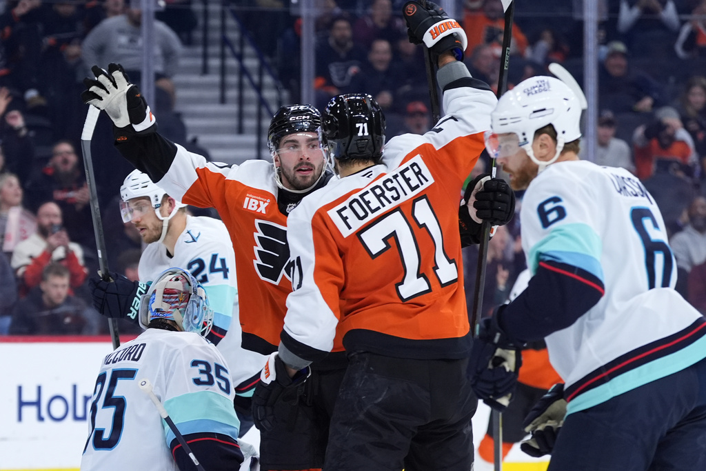 Philadelphia Flyers' Noah Cates (27) and Tyson Foerster (71) celebrate past Seattle Kraken's Joey Daccord (35) and Adam Larsson (6) after Cates' goal during the second period of an NHL hockey game Monday, Oct. 20, 2025, in Philadelphia. (AP Photo/Matt Slocum)