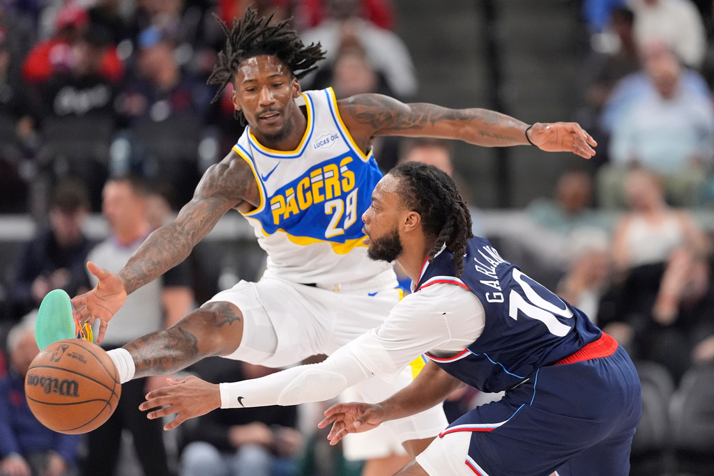 Los Angeles Clippers guard Darius Garland, right, tries to pass while under pressure from Indiana Pacers guard Quenton Jackson during the first half of an NBA basketball game Wednesday, March 4, 2026, in Inglewood, Calif. (AP Photo/Mark J. Terrill)