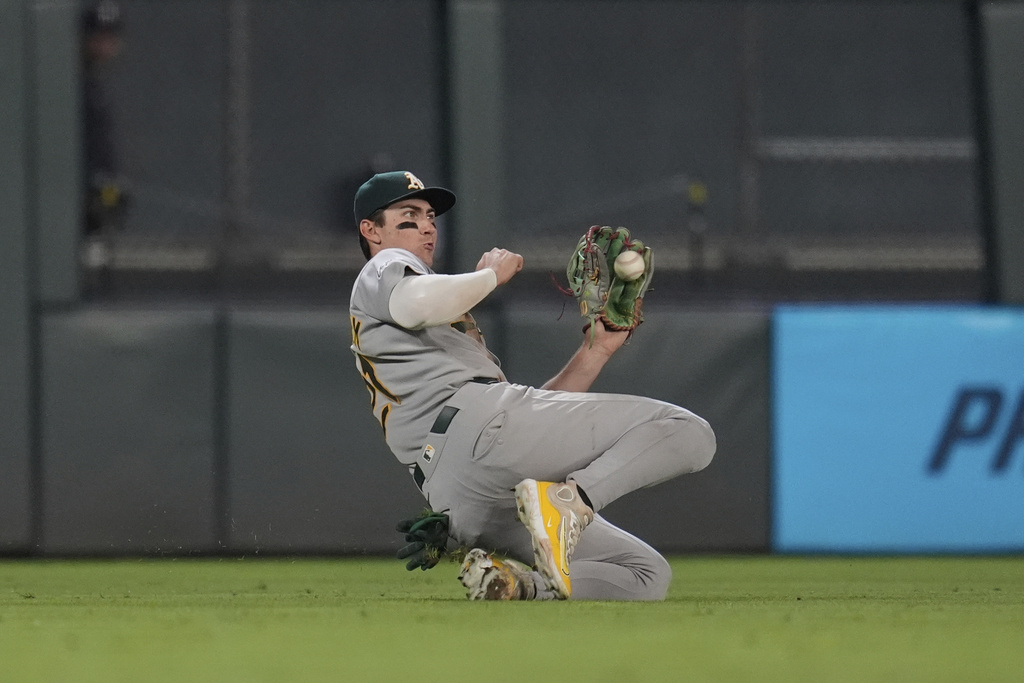 Athletics left fielder Tyler Soderstrom (21) slides to catch a line out hit by Minnesota Twins' Austin Martin (16) for the final out of a baseball game Tuesday, Aug. 19, 2025, in Minneapolis. (AP Photo/Abbie Parr)