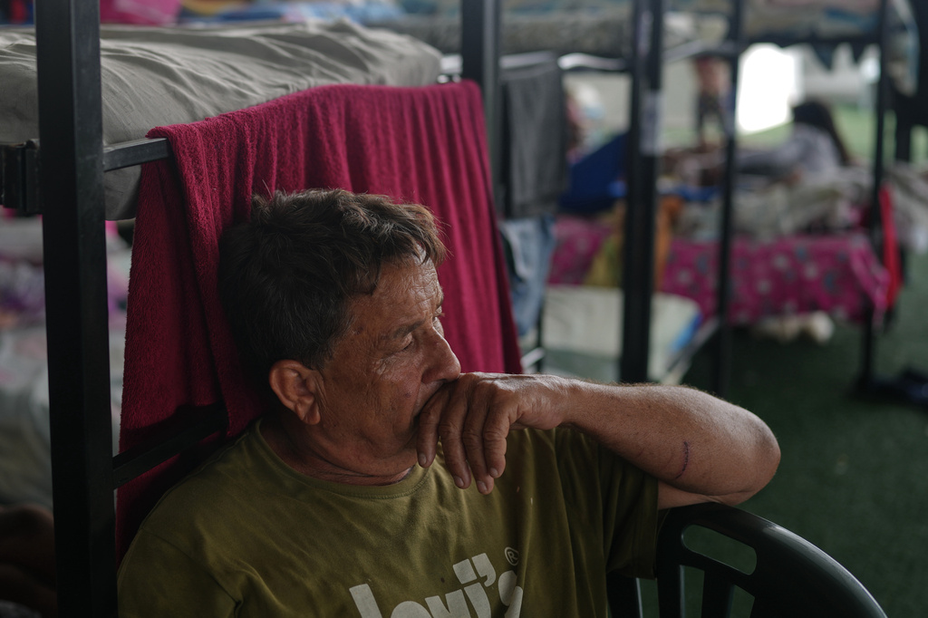 Javier Contreras sits at a sports center sheltering people displaced by the earthquakes in La Guaira, Venezuela, Thursday, July 9, 2026. (AP Photo/Ariana Cubillos)