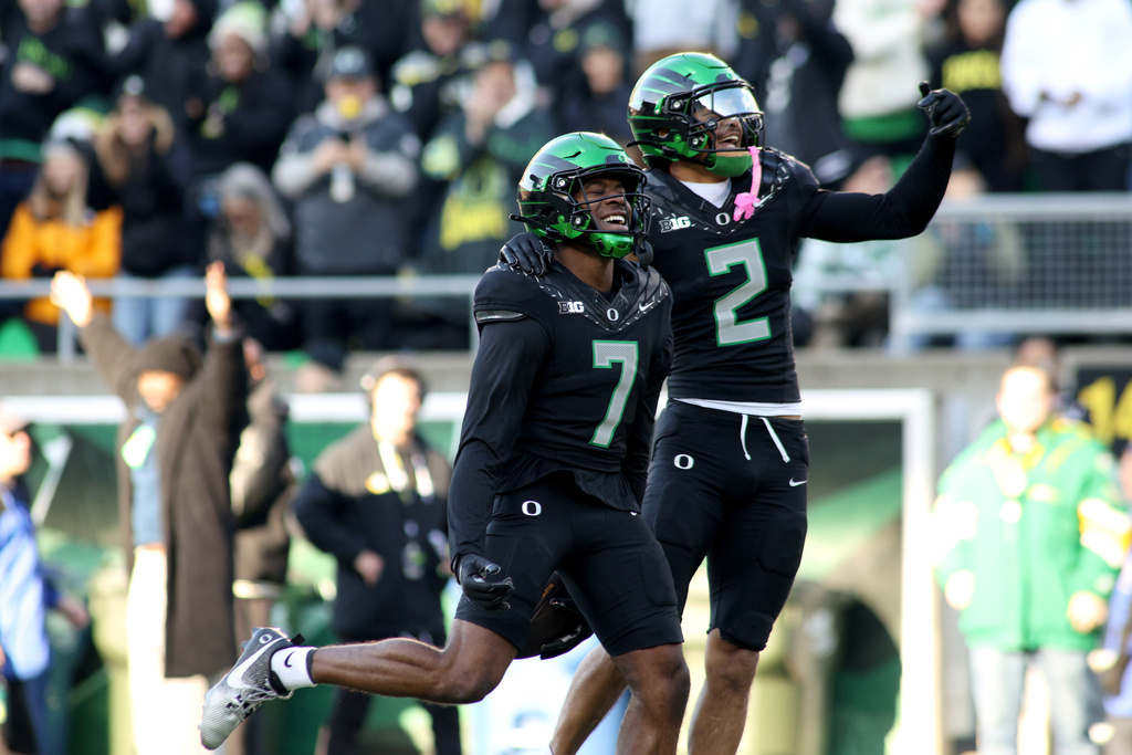 Oregon defensive back Ify Obidegwu (7) celebrates with defensive back Kingston Lopa (2) after his interception during the first half of an NCAA college football game against Southern California, Saturday, Nov. 22, 2025, in Eugene, Ore. (AP Photo/Lydia Ely)