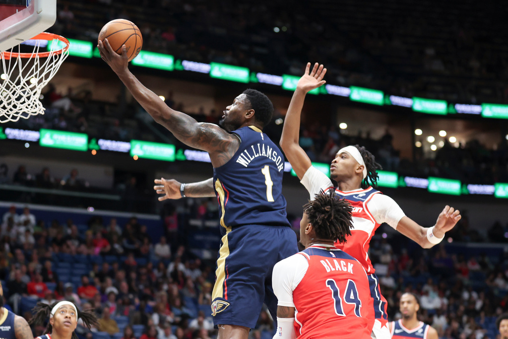 New Orleans Pelicans forward Zion Williamson (1) drives between Washington Wizards forward Leaky Black (14) and guard Bilal Coulibaly, right, for a layup in the first half of an NBA basketball game in New Orleans, Sunday, March 8, 2026. (AP Photo/Peter Forest)