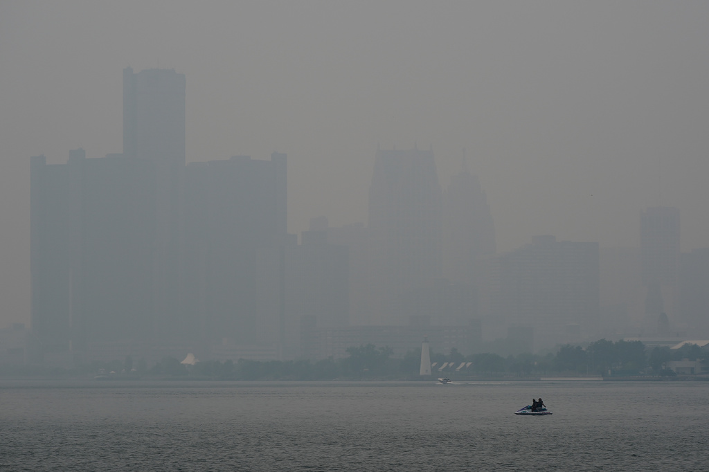 A watercraft sits in the Detroit River near the skyline during poor air quality due to smoke from Canadian wildfires Thursday, July 16, 2026, in Detroit. (AP Photo/Paul Sancya)
