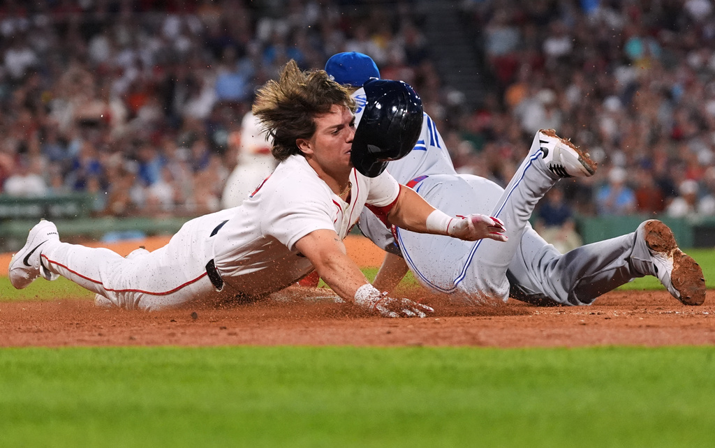 Boston Red Sox pinchhitter Nate Eaton, left, dives into first base head first as Toronto Blue Jays' Vladimir Guerrero Jr. makes the force out with bases loaded to end the fifth inning of a baseball game, Wednesday, June 17, 2026, in Boston. (AP Photo/Charles Krupa)
