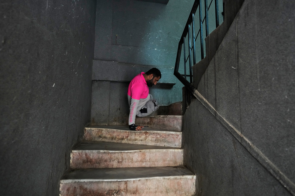 Hamza Ali, 28, who lost both legs in a road accident, moves up a flight of stairs to deliver food to a customer in Islamabad, Pakistan, Friday, July 17, 2026. (AP Photo/Anjum Naveed)