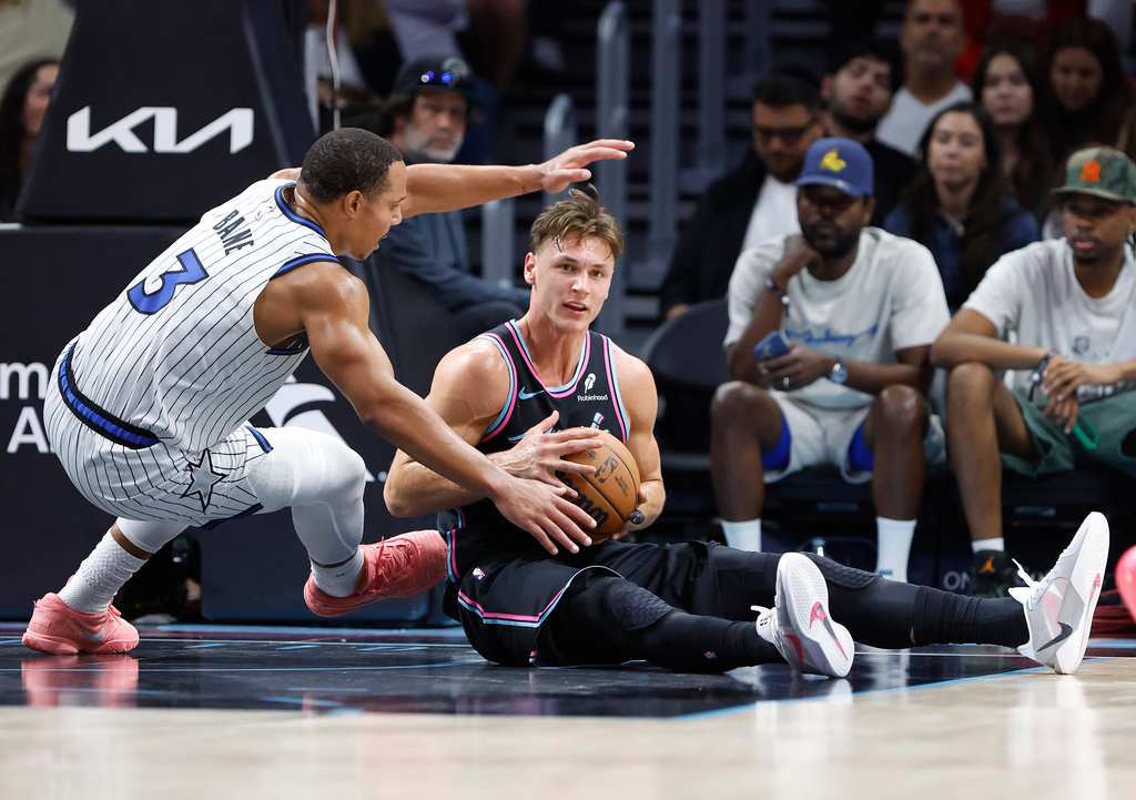 Orlando Magic guard Desmond Bane (3) defends Miami Heat guard Pelle Larsson, right, during the first half of an NBA basketball game in Miami, Saturday, March 14, 2026. (AP Photo/Rhona Wise)