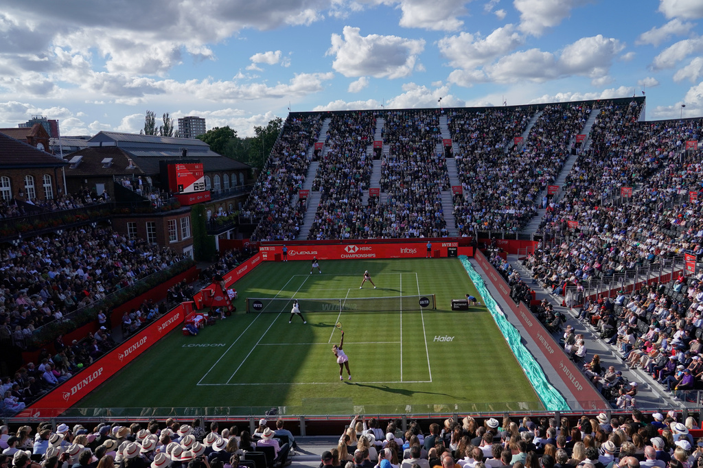 Serena Williams of the United States, bottom right, serves as she and playing partner Victoria Mboko of Canada play against Nicole Melichar-Martinez of Canada and Erin Routliffe of New Zealand during their first round doubles match at the Queen's Club tennis championships in London, Tuesday, June 9, 2026. (AP Photo/Alberto Pezzali)