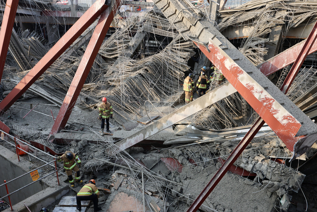 Firefighters try to rescue workers trapped under a collapsed structure at a library construction site in Gwangju, South Korea, Thursday, Dec. 11, 2025. (Cho Nam-soo/Yonhap via AP)