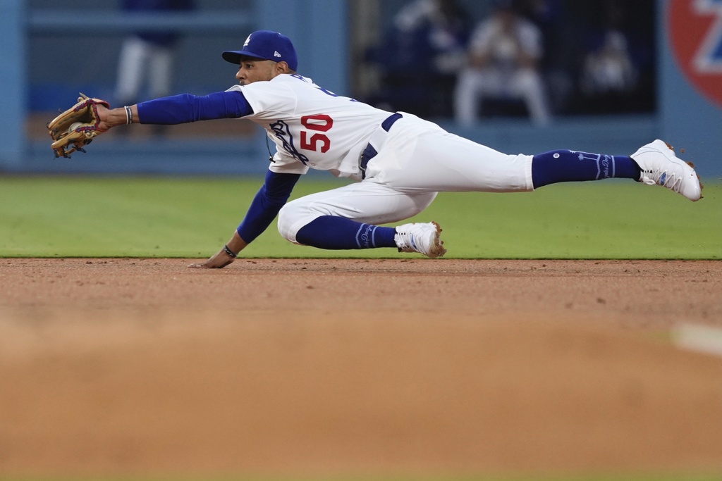 Los Angeles Dodgers shortstop Mookie Betts makes a catch on a line drive hit by Toronto Blue Jays' Myles Straw before doubling up Ty France at second during the second inning of a baseball game Friday, Aug. 8, 2025, in Los Angeles. (AP Photo/Mark J. Terrill)