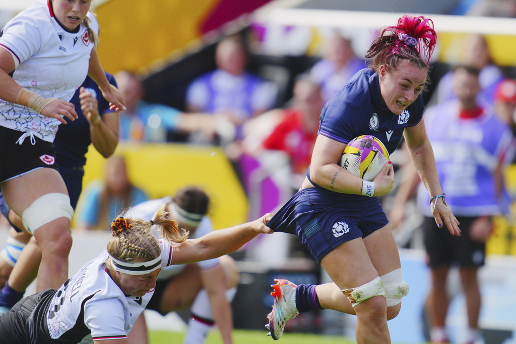 Canada's Courtney O'Donnell, bottom, tries to tackle Scotland's Evie Gallagher, right, during the Women's Rugby World Cup 2025 Pool B match between Scotland and Canada, at Sandy Park, in Exeter, England, Saturday, Sept. 6, 2025. (Ben Birchall/PA via AP)