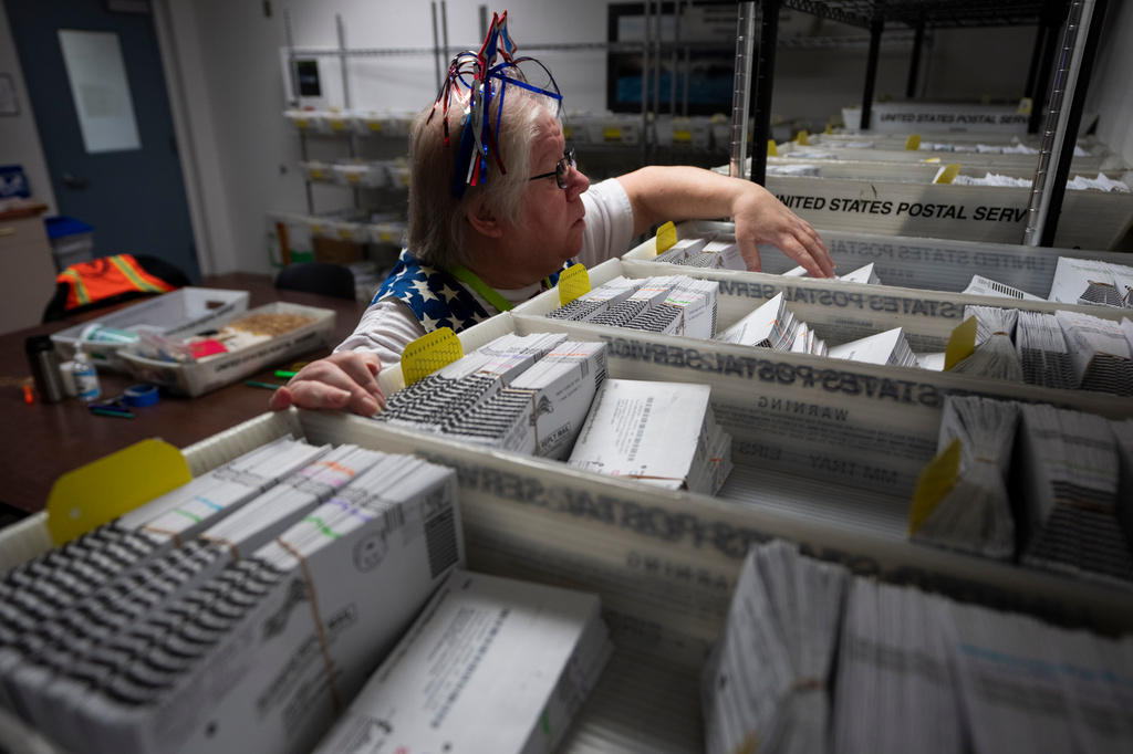 FILE - Election worker Wendy Wimer looks through vote-by-mail ballots for the presidential primary election, March 12, 2024, at the Clark County Elections Office in Vancouver, Wash. (AP Photo/Jenny Kane, File)