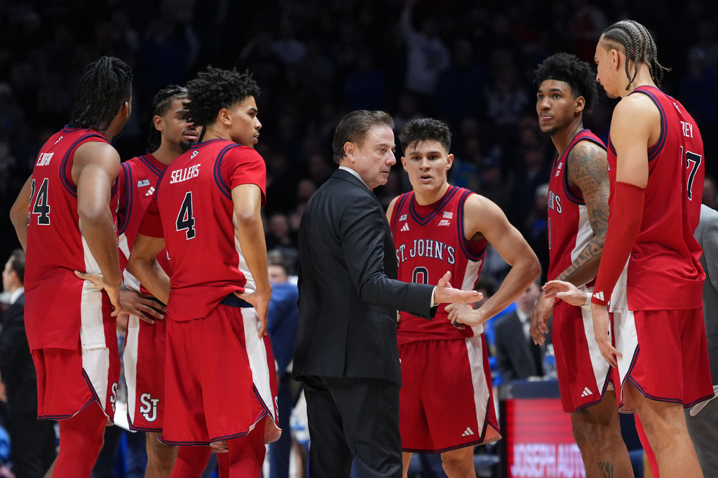 St. John's head coach Rick Pitino, center, instructs the team during a timeout in the second half of an NCAA college basketball game against Xavier, Saturday, Jan. 24, 2026, in Cincinnati. (AP Photo/Kareem Elgazzar)