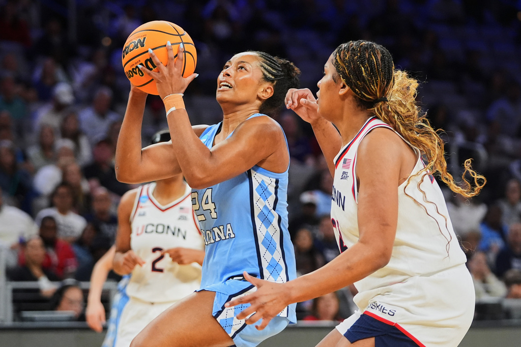 North Carolina guard Indya Nivar (24) drives to the baske past UConn forward Sarah Strong, right, in the first half in the Sweet 16 of the NCAA college basketball tournament, Friday, March 27, 2026, in Fort Worth, Texas. (AP Photo/LM Otero)