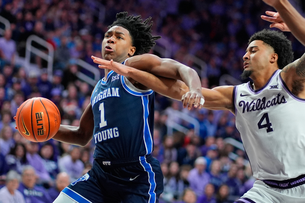 BYU guard Robert Wright III (1) gets past Kansas State guard P.J. Haggerty (4) during the first half of an NCAA college basketball game Saturday, Jan. 3, 2026, in Manhattan, Kan. (AP Photo/Charlie Riedel)