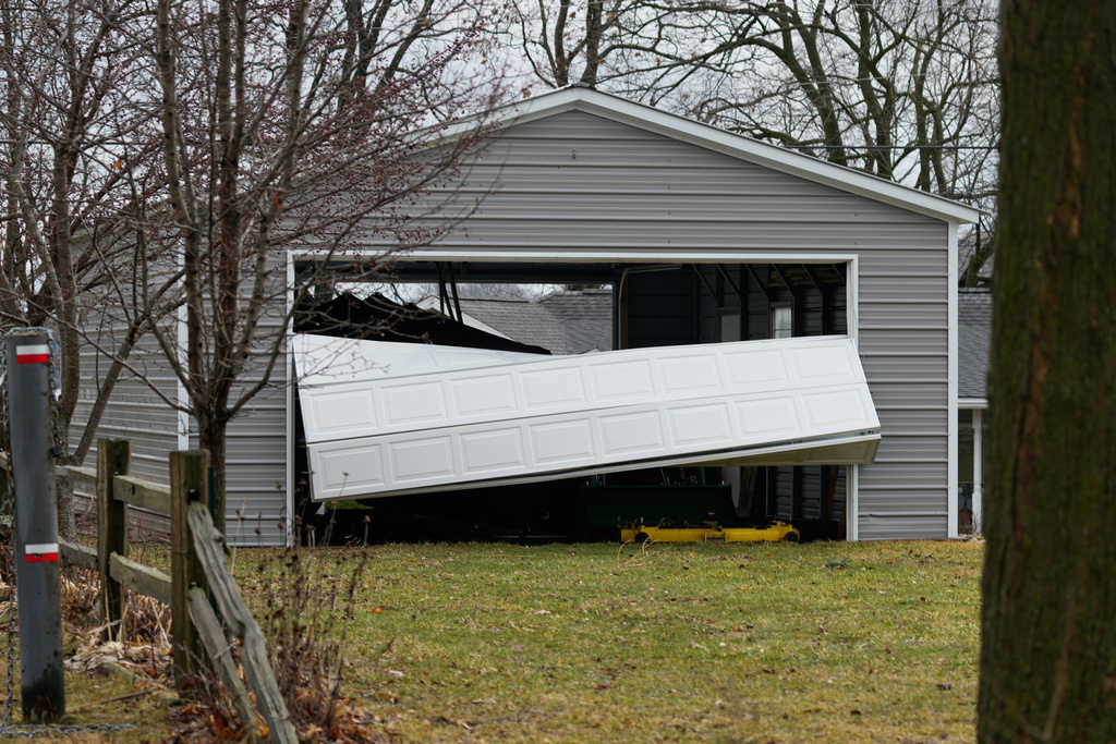 A storm-damaged garage door sits folded after a suspected tornado hit the area a day earlier, in Union City Mich., Saturday, March 7, 2026. (AP Photo/Nam Y. Huh)