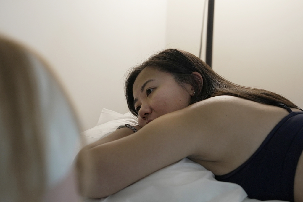 Zoë Armstrong, an endometriosis patient, rests during her pelvic floor physical therapy appointment in New York, Friday, Aug. 14, 2026. (AP Photo/Shelby Lum)