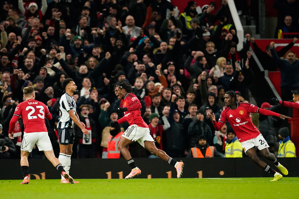 Manchester United's Patrick Dorgu, center, celebrates after scoring the opening goal during the English Premier League soccer match between Manchester United and Newcastle in Manchester, England, Friday, Dec. 26, 2025. (AP Photo/Dave Thompson)