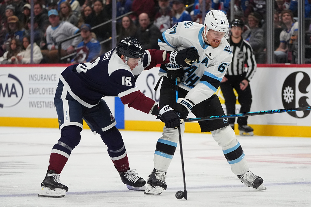 Colorado Avalanche center Jack Drury, left, battles for control of the puck with Utah Mammoth left wing Lawson Crouse in the second period of an NHL hockey game Tuesday, Dec. 23, 2025, in Denver. (AP Photo/David Zalubowski)