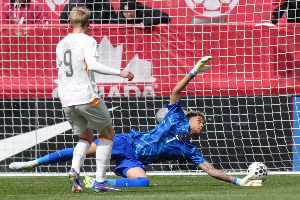 Iceland's Orri Steinn Oskarsson scores a goal past Canada goalkeeper Dayne St. Clair during an international friendly soccer match in Toronto, Saturday March 28, 2026. (Chris Young/The Canadian Press via AP)