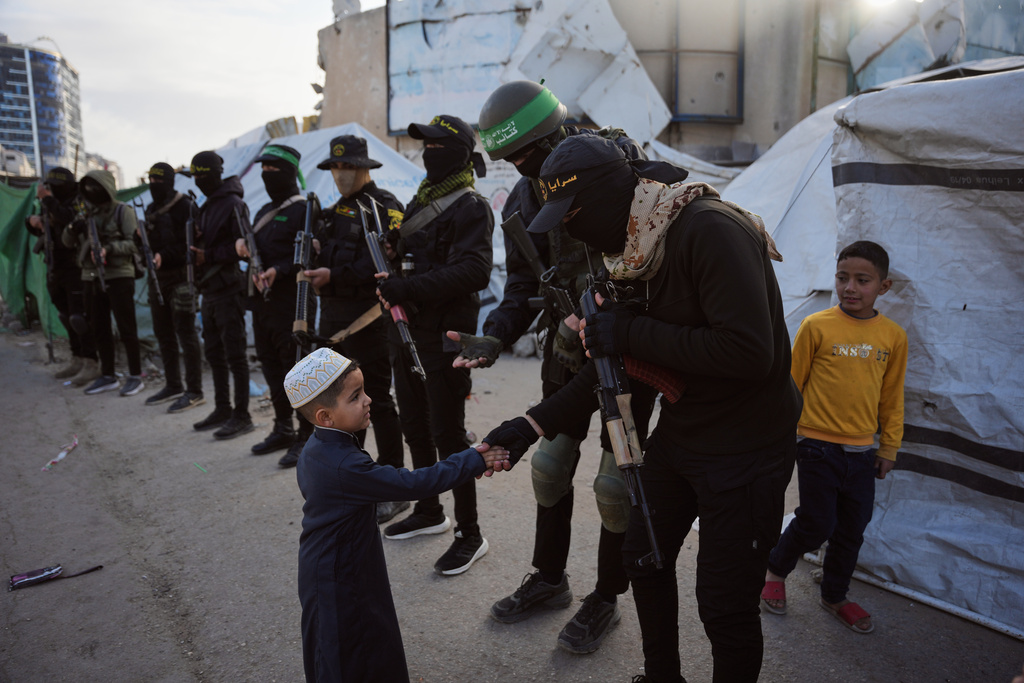Palestinian militants from Hamas and Islamic Jihad greet people who gather for to Eid al-Fitr prayers in Gaza City, Friday, March 20, 2026. (AP Photo/Abdel Kareem Hana)