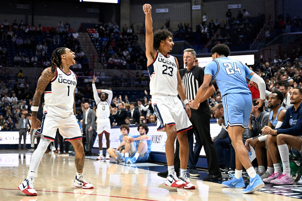 UConn guard Solo Ball (1) reacts after UConn forward Jayden Ross (23) makes a three-point basket as Columbia guard Miles Franklin (24) defends in the first half of an NCAA college basketball game, Monday, Nov. 10, 2025, in Storrs, Conn. (AP Photo/Jessica Hill)
