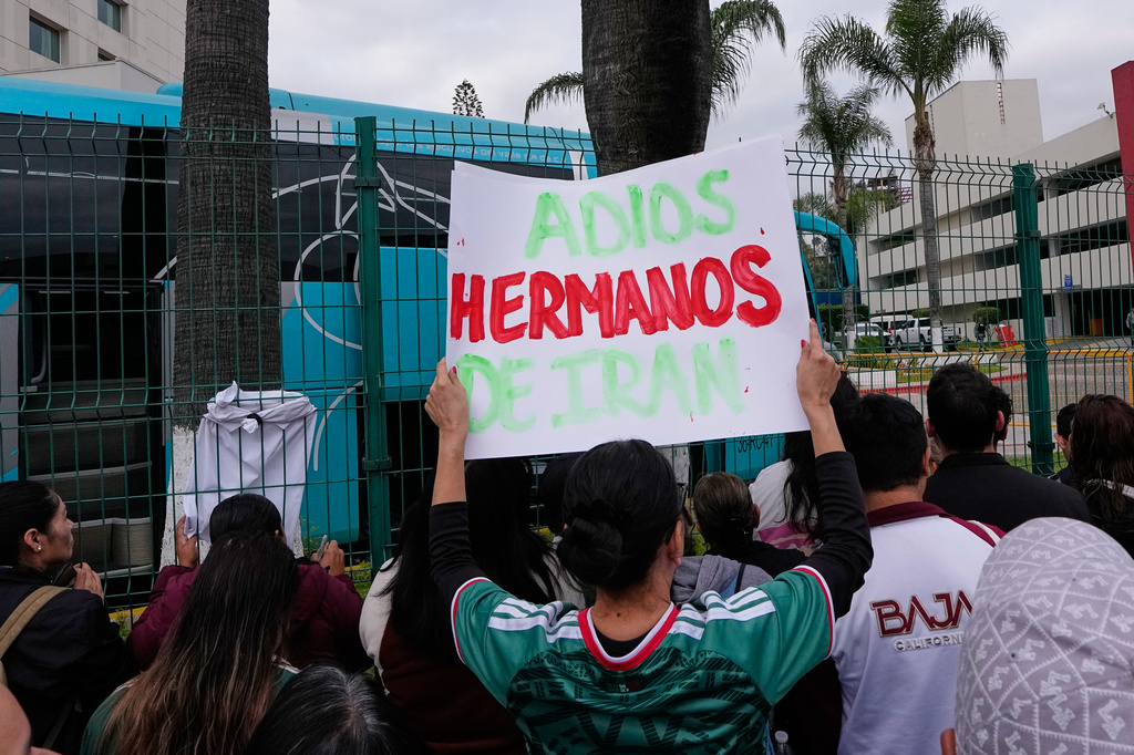 Fans greet members of the Iran World Cup soccer team as they leave their hotel for the airport Tuesday, June 30, 2026, in Tijuana, Mexico. (AP Photo/Gregory Bull)