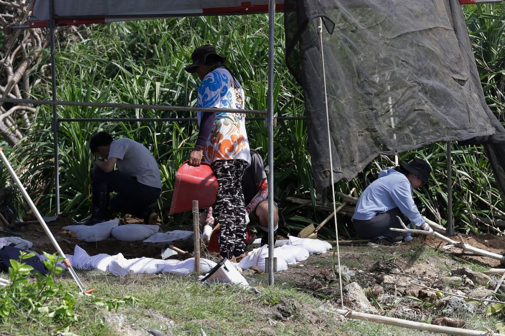 Taiwanese volunteers conducted their excavation work to find remains of Japanese soldiers who died during WWII and washed ashore on the coastline of Hengchun township, Pingtung county, southern Taiwan, Monday, July 20, 2026. (AP Photo/Chiang Ying-ying)