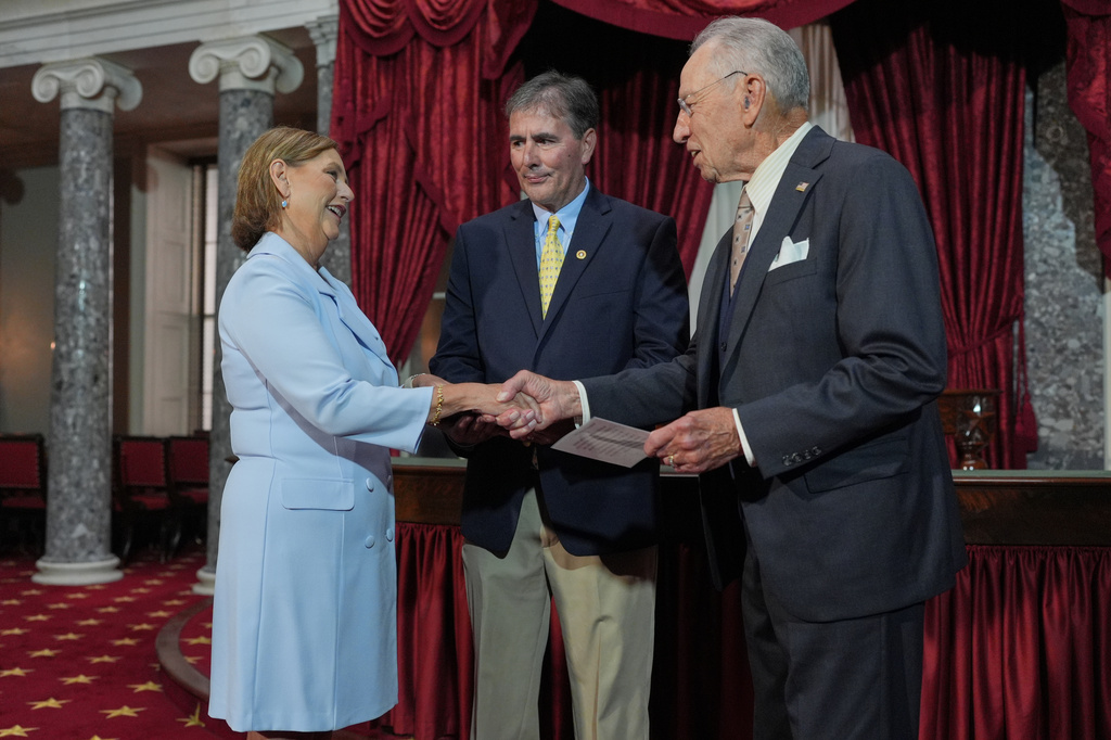 Sen. Darline Graham, R-S.C., sister of Lindsey Graham, shakes hands with President Pro Tempore of the Senate, Chuck Grassley, R-Iowa, in the Old Senate Chamber at the Capitol in Washington, after being ceremonially sworn-in Tuesday, July 14, 2026, as her husband Larry Nordone watches. (AP Photo/J. Scott Applewhite)