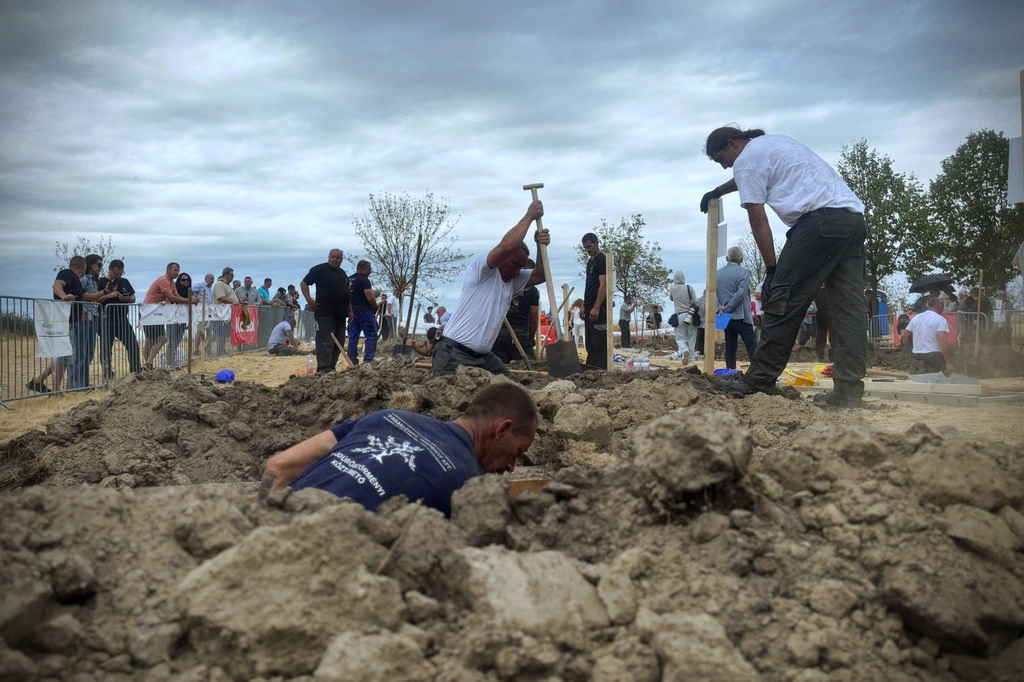 In this photo provided by Lili Szandelszky, gravediggers compete in a contest, aimed at shaking off death-related taboos, in the public cemetery of Nyergesújfalu, Hungary, Saturday, Sept. 5, 2026. (Lili Szandelszky via AP)