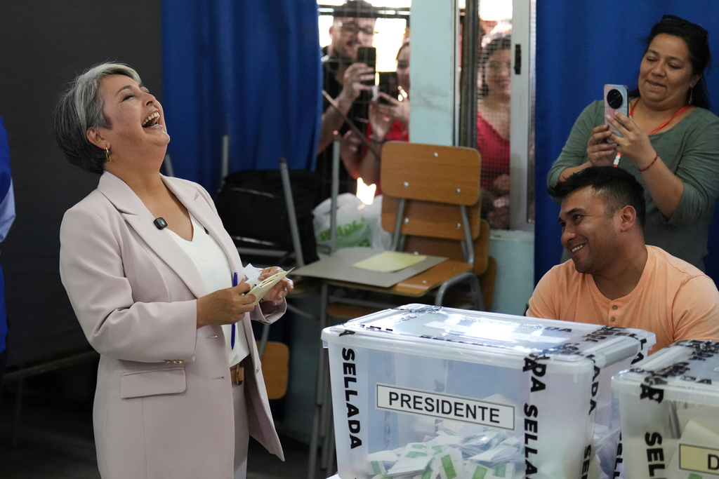 Presidential candidate Jeannette Jara of the Unidad por Chile coalition laughs while holding her ballot during general elections in Santiago, Chile, Sunday, Nov. 16, 2025. (AP Photo/Natacha Pisarenko)