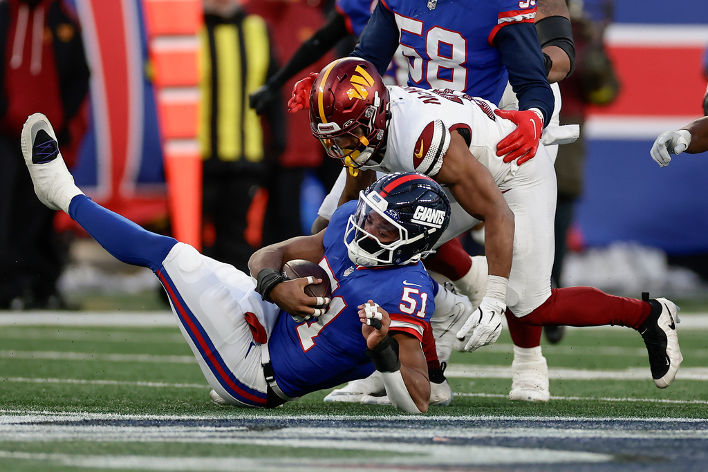 New York Giants linebacker Abdul Carter (51) recovers a fumble by the Washington Commanders during the fourth quarter of an NFL football game, Sunday, Dec. 14, 2025, in East Rutherford, N.J. (AP Photo/Adam Hunger)