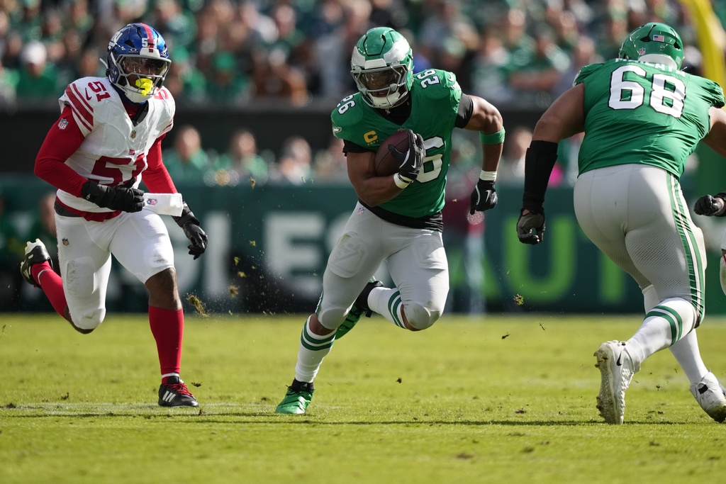 Philadelphia Eagles running back Saquon Barkley (26) runs with the ball near New York Giants linebacker Abdul Carter (51) during the first half of an NFL football game Sunday, Oct. 26, 2025, in Philadelphia. (AP Photo/Matt Slocum)