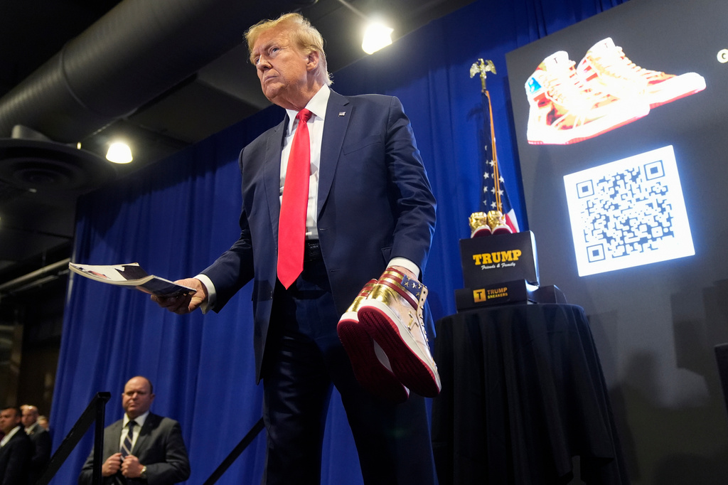 FILE - Donald Trump hold a Playboy magazine and gold Trump sneakers at Sneaker Con Philadelphia, an event popular among sneaker collectors, in Philadelphia, Saturday, Feb. 17, 2024. (AP Photo/Manuel Balce Ceneta, File)