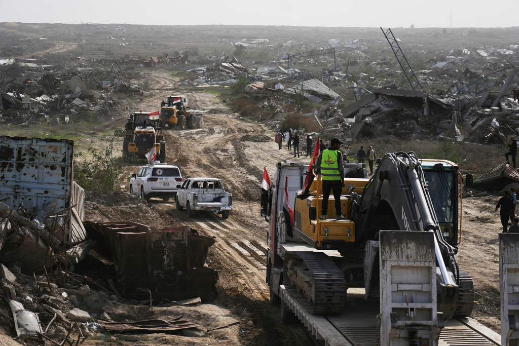 FILE - Hamas militants and Egyptian workers accompanied by members of the International Committee of the Red Cross (ICRC) head to Zeitoun neighborhood of Gaza City to search for the remains of deceased hostages, Dec. 8, 2025. (AP Photo/Jehad Alshrafi, File)