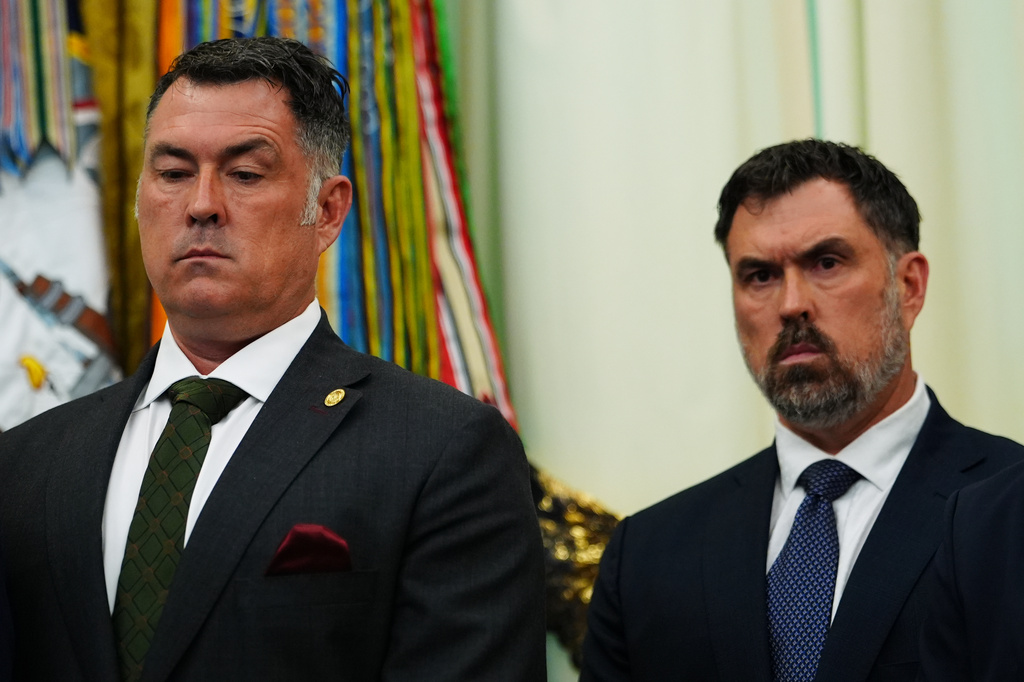 Marcus Luttrell, a retired U.S. Navy Seal, and his brother, Rep. Morgan Luttrell, R-Texas, listen to President Donald Trump speak in the Oval Office of the White House, Saturday, April 18, 2026, in Washington. (AP Photo/Julia Demaree Nikhinson)