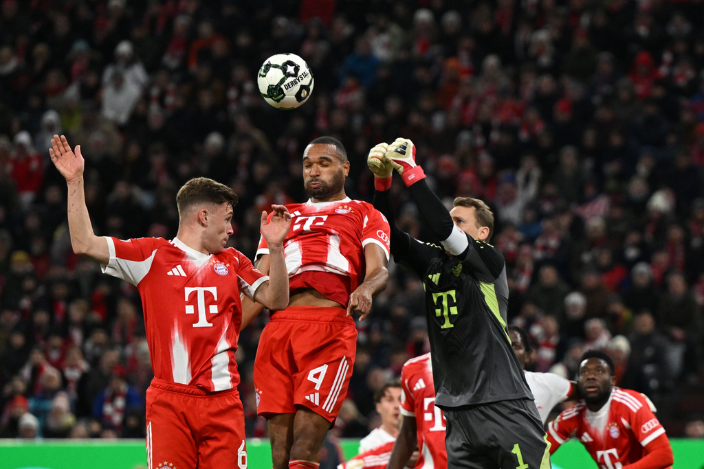 FC Bayern Munich goalkeeper Manuel Neuer, right, defends a shot next to teammates Jonathan Tah, center, and Joshua Kimmich during the German Cup soccer match between Bayern Munich and RB Leipzig in Munich, Germany, Wednesday, Feb. 11, 2026. (Sven Hoppe/dpa via AP)