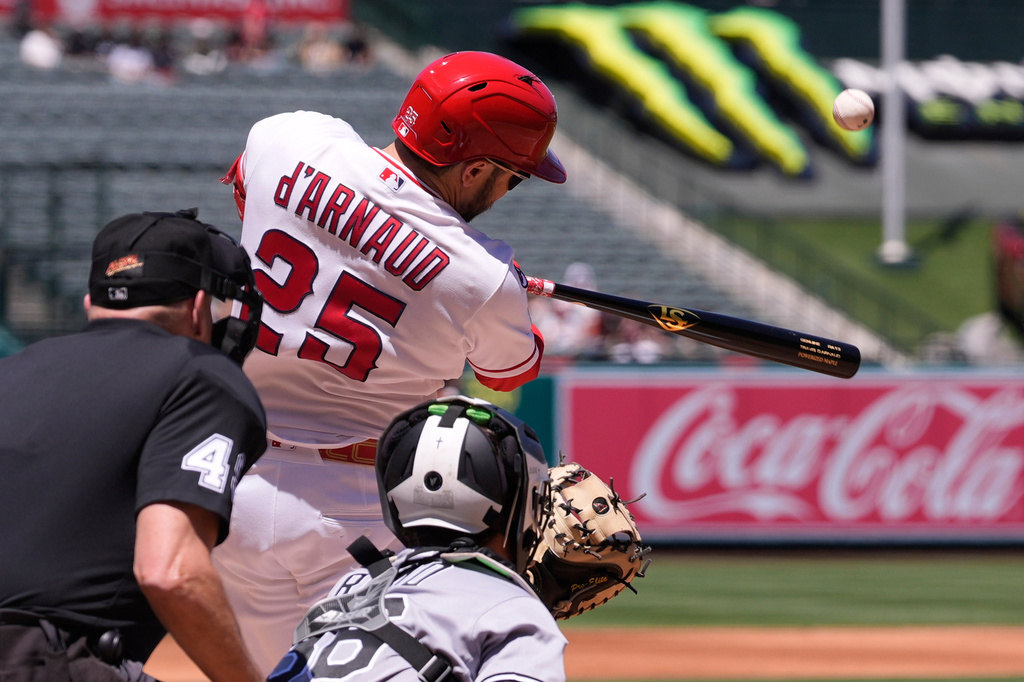Los Angeles Angels' Travis D'Arnaud, center, hits a three-run home run as Chicago White Sox catcher Drew Romo, right, and home plate umpire Andy Fletcher watch during the second inning of a baseball game Wednesday, May 6, 2026, in Anaheim, Calif. (AP Photo/Mark J. Terrill)