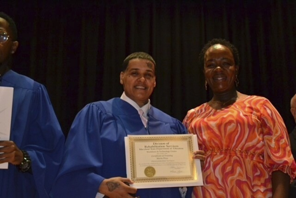In this photo courtesy of Maria Pires, Maria Pires stands beside Marcia Neal of the Maryland Division of Rehabilitation Services at her graduation from a Rehabilitation Services program, near Baltimore, Maryland, May 30, 2024. (Maria Pires via AP)