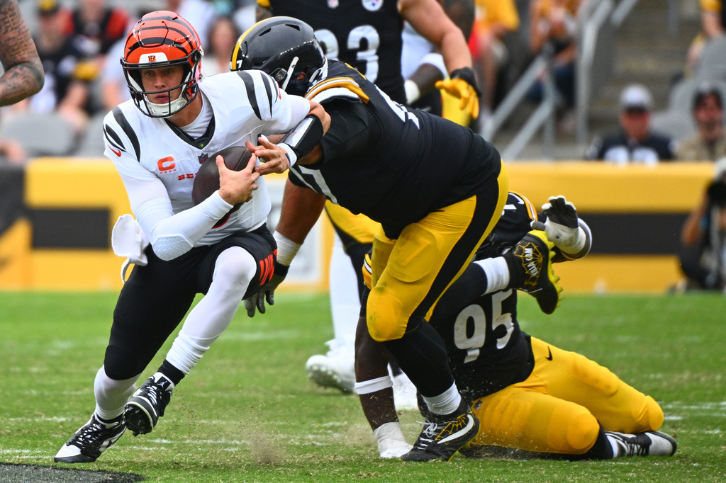 Cincinnati Bengals quarterback Joe Burrow, left, runs with the ball during the second half of an NFL football game against the Pittsburgh Steelersin Pittsburgh, Sunday, Sept. 27, 2026. (AP Photo/Justin Berl)