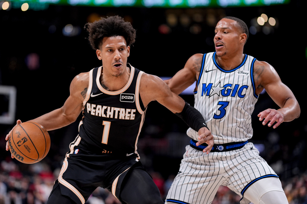 Atlanta Hawks forward Jalen Johnson (1) drives against Orlando Magic guard Desmond Bane (3) during the first half of an NBA basketball game, Monday, March 16, 2026, in Atlanta. (AP Photo/Mike Stewart)