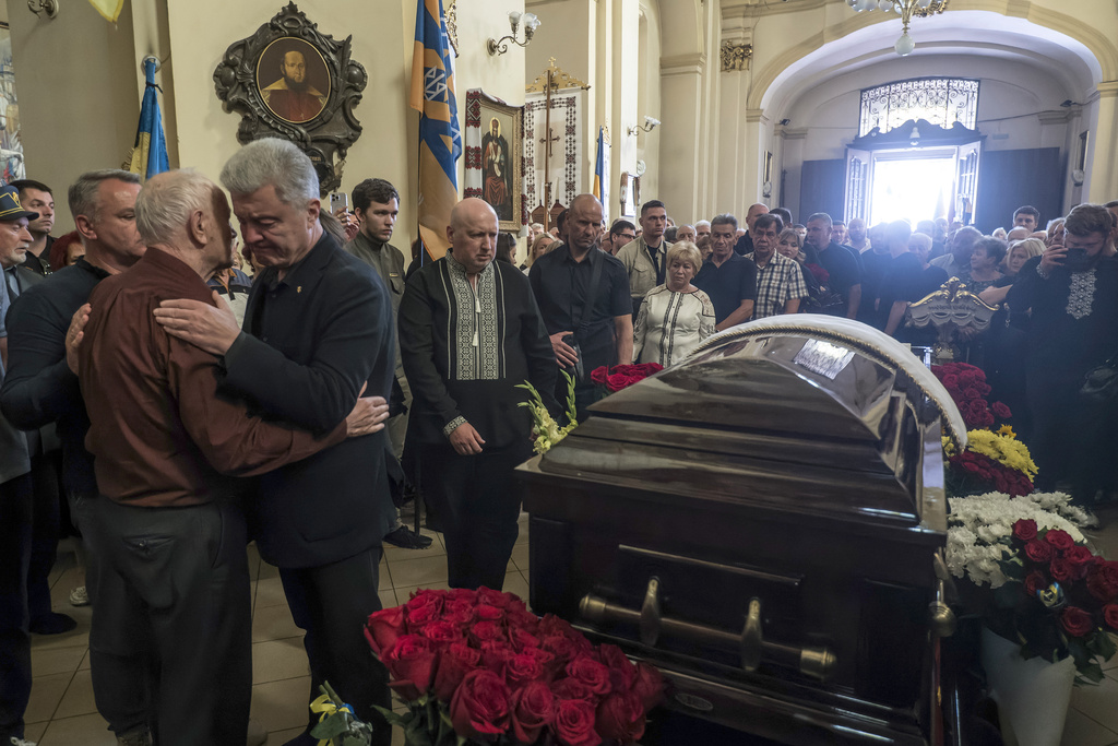 People mourn near the coffin of former Ukrainian parliament speaker Andriy Parubiy, who was killed last Saturday in Lviv, Ukraine, Tuesday, Sept. 2, 2025. (AP Photo/Vladyslav Musiienko)