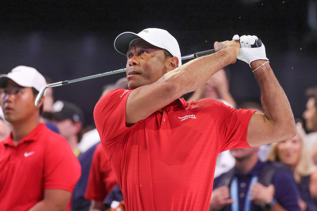 Tiger Woods hits a practice iron from a grass pad before the TGL finals golf tournament in Palm Beach Gardens, Fla., Tuesday, March 24, 2026. (AP Photo/Reinhold Matay)