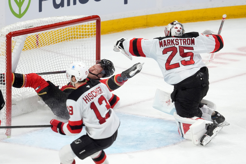 Ottawa Senators left wing Brady Tkachuk (7) crashes into the net after colliding with New Jersey Devils goaltender Jacob Markstrom (25) during third period NHL action, in Ottawa, Tuesday, Dec. 9, 2025. (Adrian Wyld/The Canadian Press via AP)