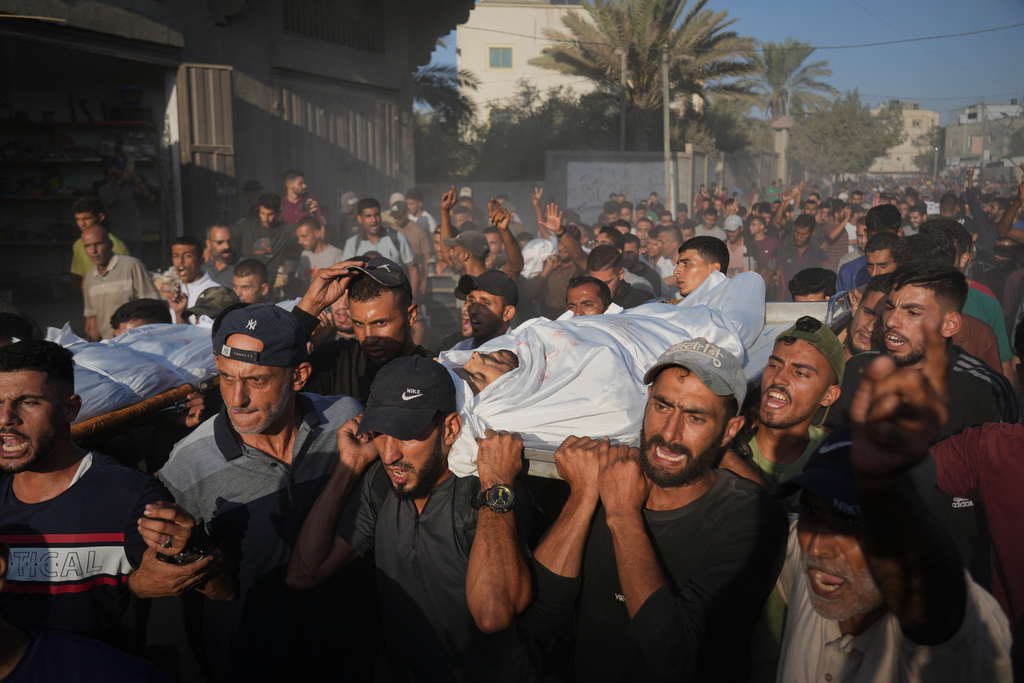 Mourners carry bodies of Palestinians killed by Israeli fire, during their funeral in Deir al-Balah, Gaza Strip, Sunday, Oct. 19, 2025. (AP Photo/Abdel Kareem Hana)