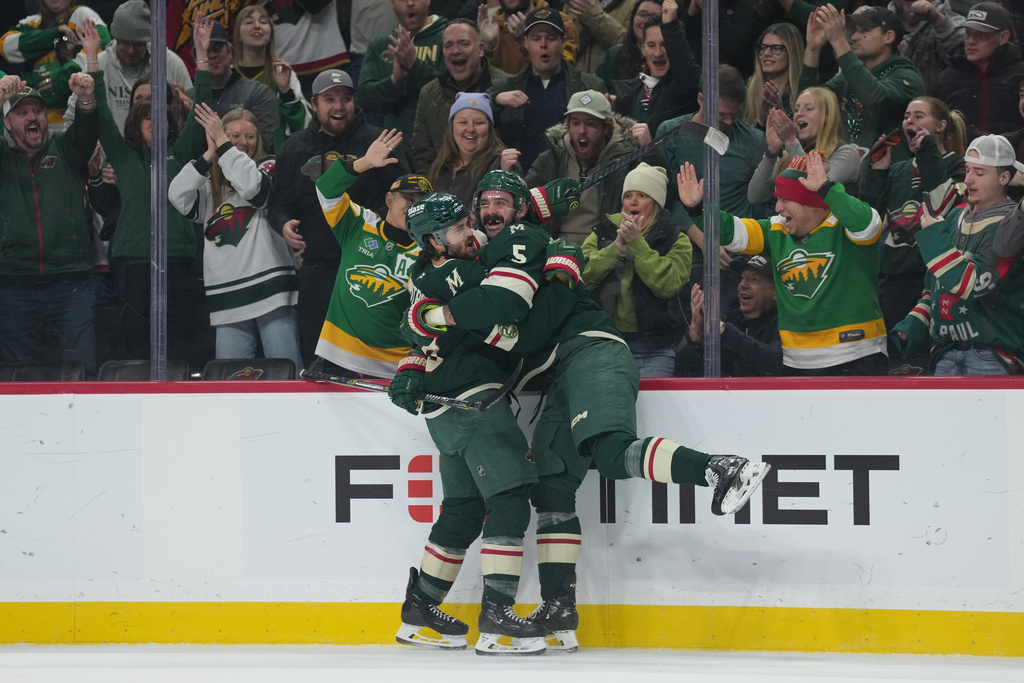 Minnesota Wild center Vinnie Hinostroza (18), left, celebrates with defenseman Jake Middleton (5) after scoring a goal during the first period of an NHL hockey game against the Calgary Flames, Thursday, Jan. 29, 2026, in St. Paul, Minn. (AP Photo/Abbie Parr)