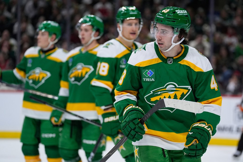 Minnesota Wild defenseman Quinn Hughes (43), right, waits for play to resume during the second period of an NHL hockey game against the Washington Capitals, Tuesday, Dec. 16, 2025, in St. Paul, Minn. (AP Photo/Abbie Parr)