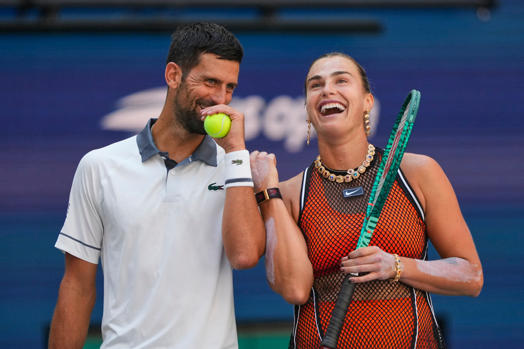Novak Djokovic, of Serbia, left, and Aryna Sabalenka, of Belarus, share a laugh during a mixed doubles match at the U.S. Open tennis championships, Tuesday, Aug. 25, 2026, in New York. (AP Photo/Yuki Iwamura)