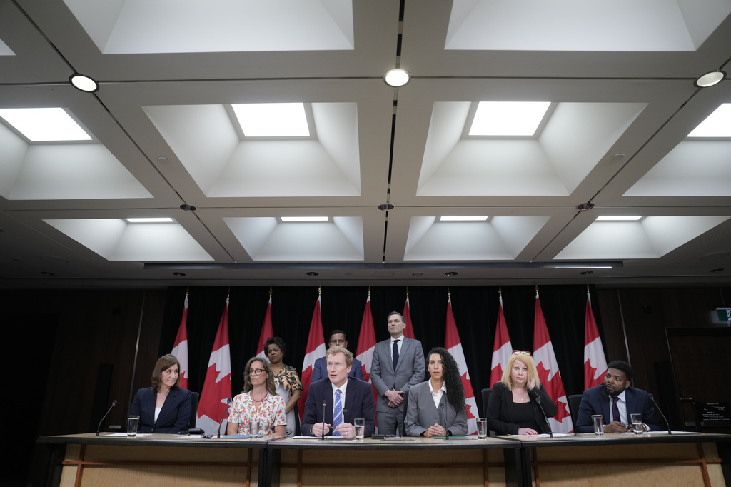 Canadian Identity and Culture Minister Marc Miller speaks as colleagues and medical professionals look on during a news conference in Ottawa, Ontario, Wednesday, June 10, 2026. (Adrian Wyld/The Canadian Press via AP)