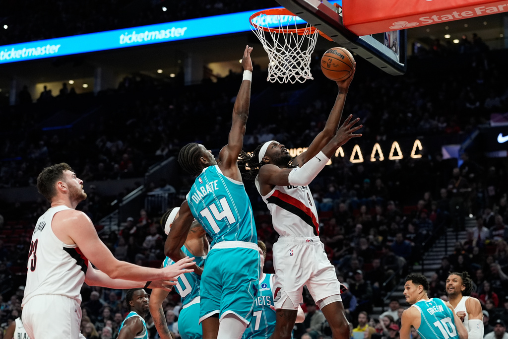Portland Trail Blazers forward Jerami Grant (9) shoots as Charlotte Hornets forward Moussa Diabaté (14) defends during the first half of an NBA basketball game Tuesday, March 10, 2026, in Portland, Ore. (AP Photo/Jenny Kane)