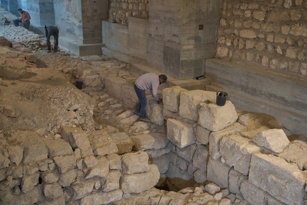 Workers from the Israel Antiquities Authority clean a section of an excavation site where, according to the institution, a city wall from the Hasmonean period, dating to the late 2nd century BCE, was uncovered under the Tower of David Citadel Museum, in the Old City of Jerusalem, Monday, Dec. 8, 2025. (AP Photo/Leo Correa)